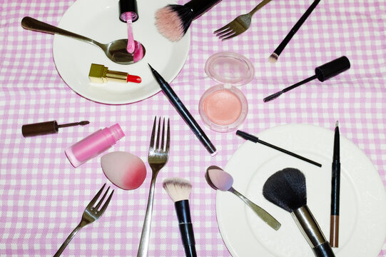 Conceptual image of makeup beauty products on picnic blanket and plate