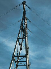 A high-voltage pole with wires and insulators on a clear sky background. The topic of energy,...