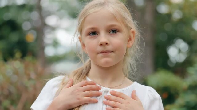 Outdoor blonde girl with hands on chest