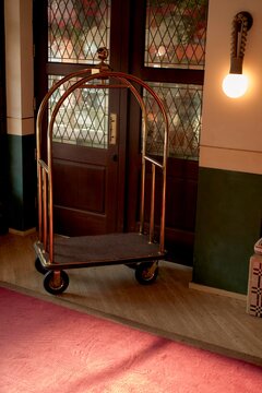 Elegant Hotel Cart Waiting Near Wooden Doors in a Warm Entrance