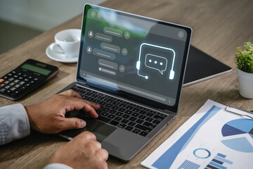 Businessman using AI chatbot interface on laptop for digital contact center support chatbot...
