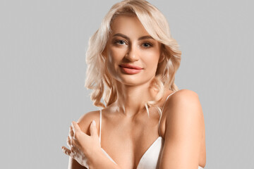 Obraz premium Pretty young woman with curly blonde hair on white background