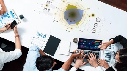 A vibrant office scene featuring a collaborative team analyzing data and creating visualizations using laptops and charts on a bright table, showcasing teamwork and innovation. Raster - Powered by Adobe