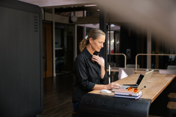 Businesswoman working on laptop in modern office environment