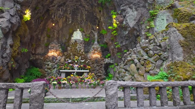 A scenic view of the Grotto, formally the National Sanctuary of Our Sorrowful Mother, an iconic Catholic shrine and botanical garden carved into a cliff face in Portland, Oregon