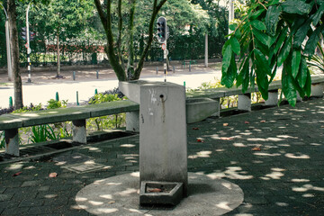 Water fountain in a quiet park under leafy trees during the day