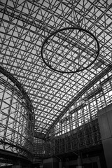 金沢駅の天井を撮影した写真。伝統的な木組みの鼓門とガラスドームが印象的で、広々とした開放感あふれる空間を演出しています。
