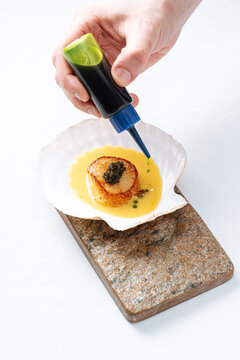 Seared scallop with caviar in shell plating