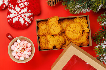 Gingerbread cookies, cup with marshmallows and snowy fir branches