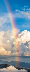 Majestic Rainbow Over Clouds and Mountains Underclear Blue Sky