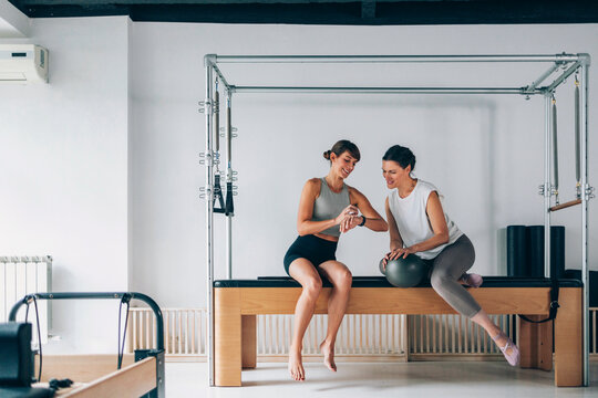Two Women Practicing Fitness on Specialized  Equipment