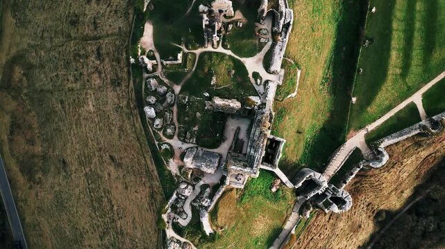 Aerial Drone Footage of Corfe Castle in England &mdash; Historic Medieval Ruins, Scenic Countryside Views, and Dramatic Ancient Landmark Rising Above the Landscape