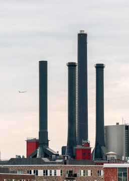 Industrial Chimneys with Airplane in Sky