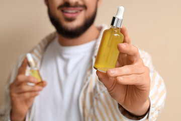 Fototapeta premium Man holding dropper bottle with natural skincare serum, organic cosmetic product for healthy skin and hair care