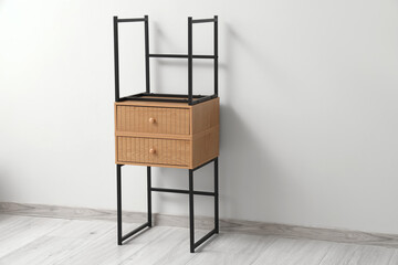 Wooden bedside tables near grey wall in room