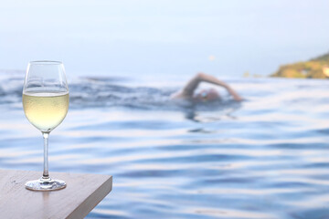 glass of cold white wine on the summer seashore by the water, relaxing by the water, a gentle background of soft color