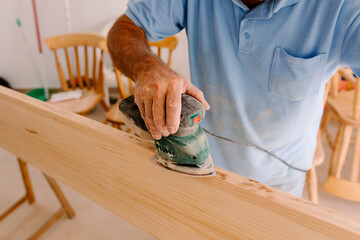 Anonymous carpenter working on the edges of a wooden board
