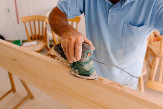 Anonymous carpenter working on the edges of a wooden board
