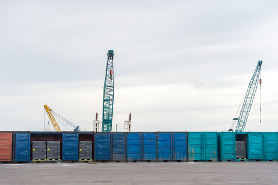 Cargo Containers Lined up at a Shipping Yard With Cranes in View