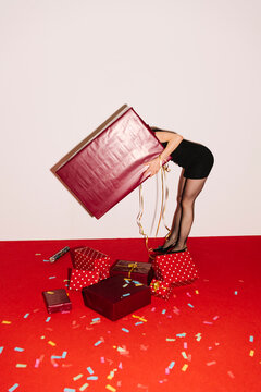 Person Bending With Large Pink Gift Bag and Presents