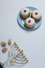 Hanukkah celebration with menorah, dreams, gifts and traditional donuts on a white background.
