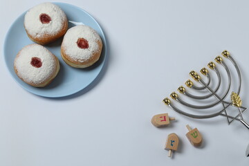 Hanukkah celebration with menorah, dreams, gifts and traditional donuts on a white background.
