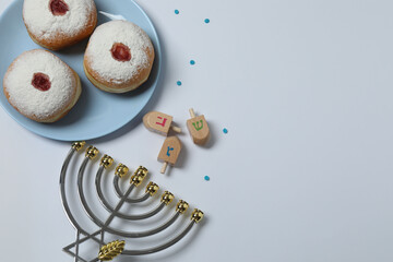 Hanukkah celebration with menorah, dreams, gifts and traditional donuts on a white background.

