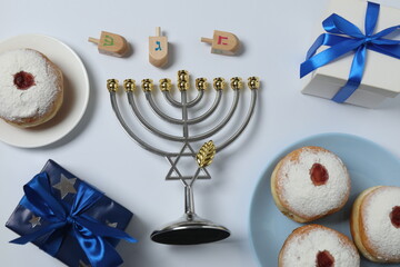 Hanukkah celebration with menorah, dreams, gifts and traditional donuts on a white background.
