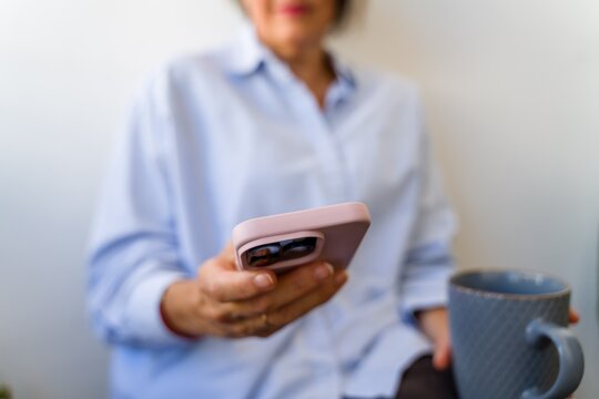 Checking phone with coffee