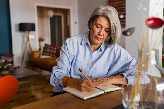 Writing in notebook at home