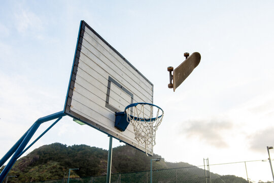 Skateboard Flying Over Basketball Hoop