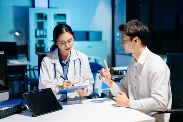 Asian doctor comforting stressed patient in hospital office, offering emotional support and professional mental health consultation with empathy and care.