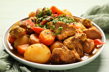 Bowl of tasty beef stew on wooden background, closeup