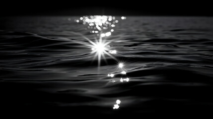 Sunlight sparkles on gentle ocean waves in a black and white photograph, highlighting the reflective surface and creating a serene, minimalist scene