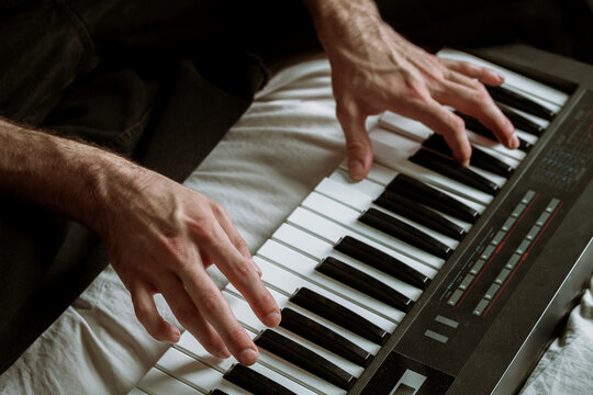 Hands Playing a Keyboard on a Soft White Surface