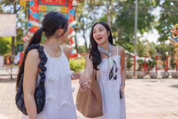 Fototapeta premium Happy young asian women holding hands smiling outdoors