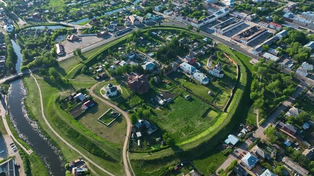 Wide aerial view of the ancient Suzdal Kremlin fortress, surrounded by earthen ramparts and the rural town