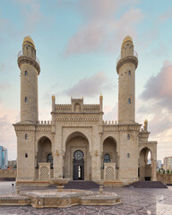 Breathtaking sunset captures the majesty of Taza Pir Mosque in Baku, Azerbaijan. The mosque intricate architecture and twin minarets stand tall against the serene backdrop of an early evening sky