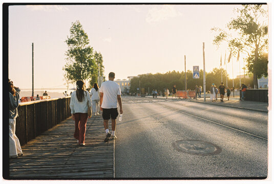 People Sunset Stroll by Lisbon Waterfront