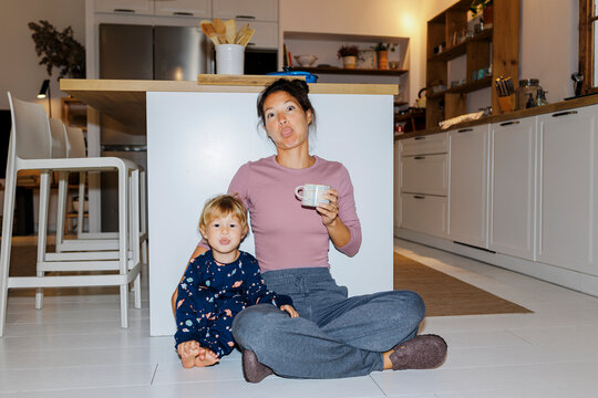 Mother and son making funny faces in kitchen ugc
