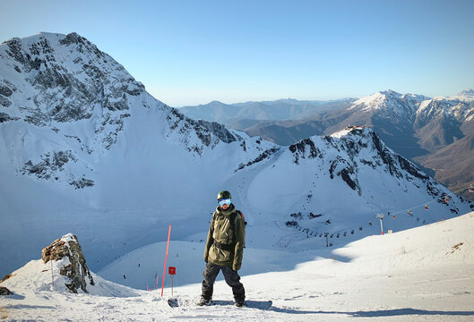 Snowboarder standing on mountain slope view