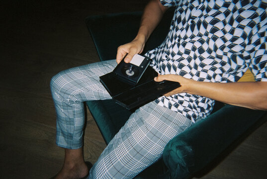 man removes a home video tape from its box, 35mm film