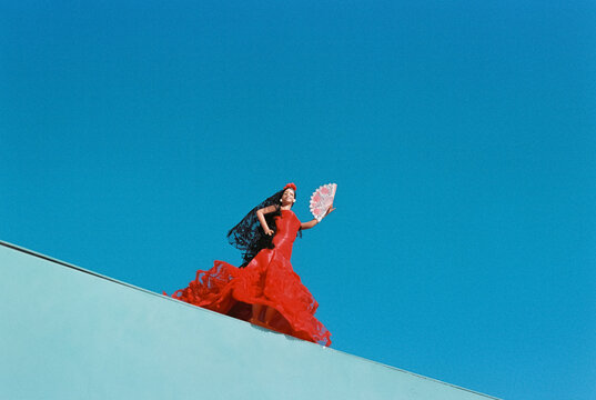 a flamenco doll in a red dress with a fan, 35mm film