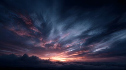 Obraz premium Dramatic sunset sky with swirling clouds in vibrant hues veiled by atmospheric mist