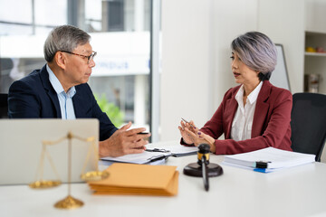 Attorney performs legal tasks to prepare cases. Lawyers at desk consulting, discussing to advise and represent client in criminal or civil proceeding, legal matter.