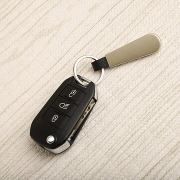 Black Electronic Car Keychain with Metal Keychain Standing on Desk