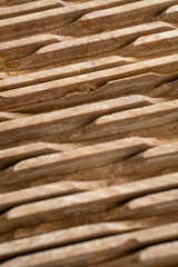 Abstract close up of textured wavy sandstone wall panel. Natural brown stone background with carved lines and selective focus