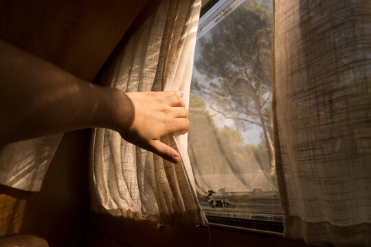 Soft morning light enters through a curtain in a quiet camper van