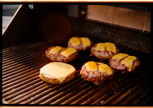 Juicy Burgers Sizzling on a Grill in a Backyard Barbecue
