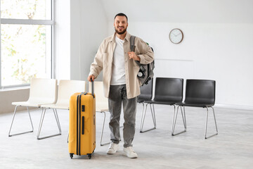 Young man with luggage in airport lounge
